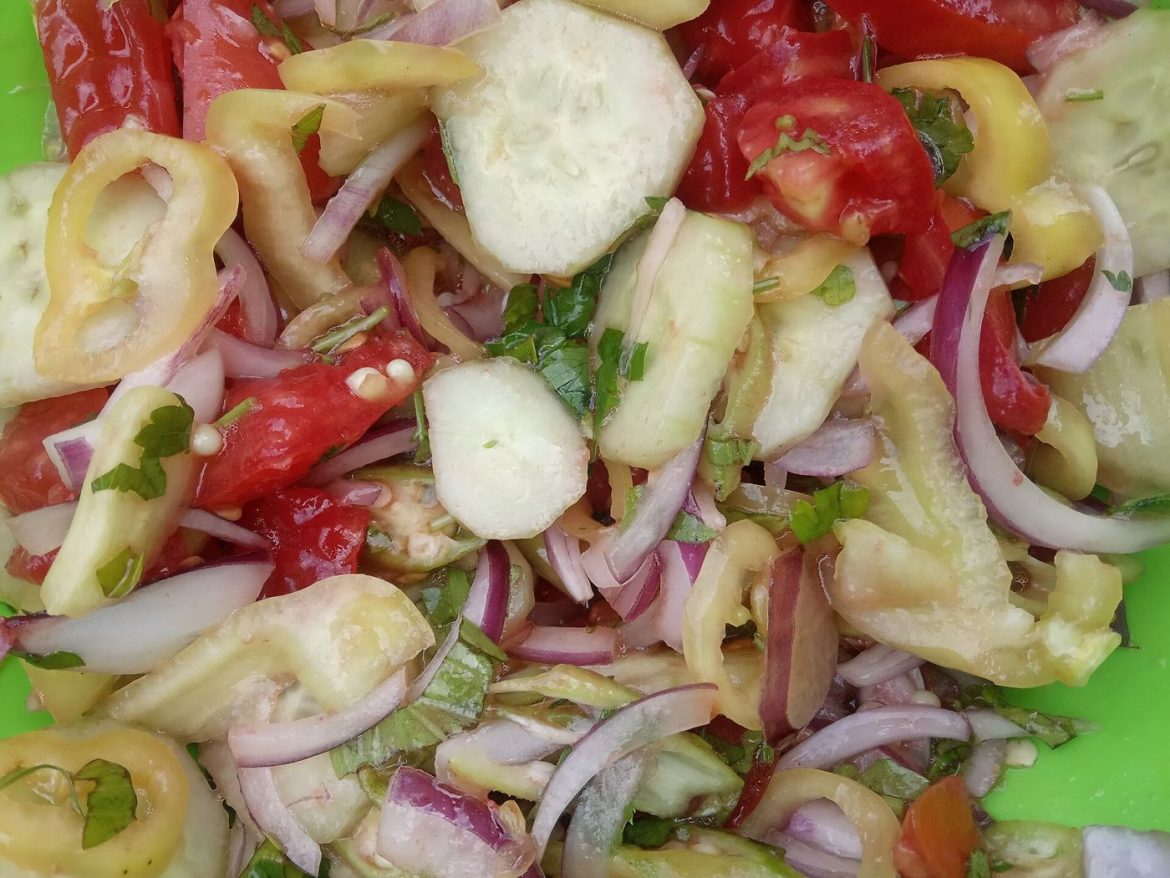 bowl of fresh vegetables with olive oil on a table